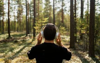 Man walking in the woods and listening to the best fishing podcasts